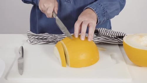 Woman Cutting Melon on Cutting Board