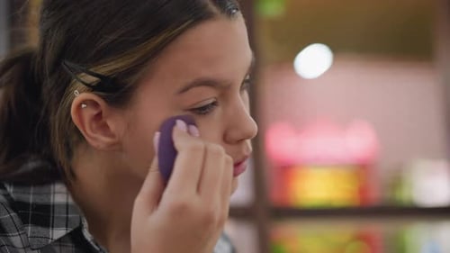 Teen Applies Makeup to Face with Sponge