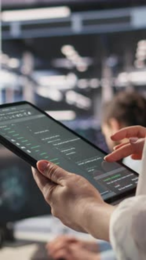 Vertical Video Close Up of Data Center System Administrator Coding on Tablet