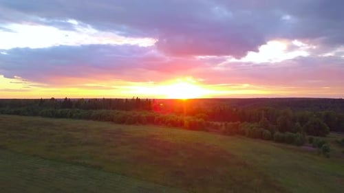 Vivid Vibrant Sunset Above Green Rural Countryside Fields and Trees