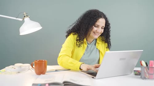 Young woman looking at laptop is happy and dancing.
