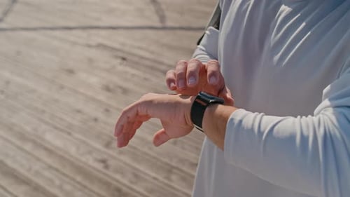Young Man Checking Smartwatch After Workout Outdoors