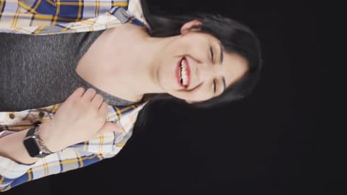 Woman Smiling and Laughing Against Black Background