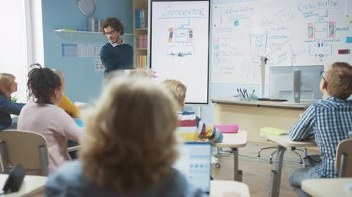 Elementary School Physics Teacher Uses Interactive Digital Whiteboard to Show to a Classroom full o