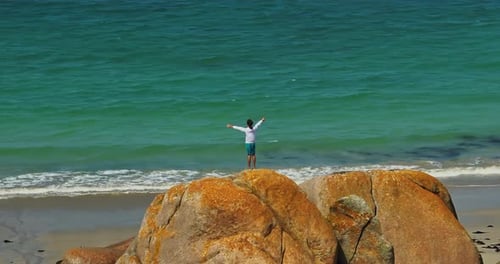 Young Guy Standing on Huge Stones on the Shore of the Atlantic Ocean on the Coast of Brittany on the