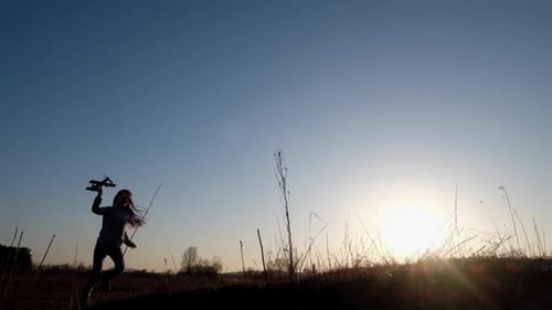 Girl Runs with Toy Airplane at Sunset
