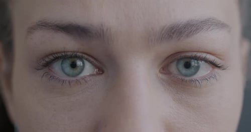 Closeup Slow Motion Portrait of Beautiful Young Woman's Eyes Looking at Camera