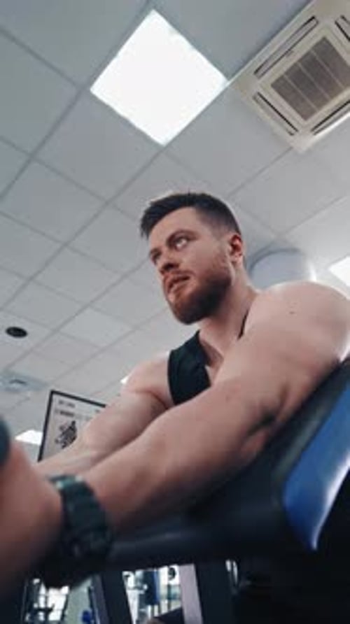 Man Working Out on Weight Machine at Gym