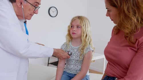 Doctor Examining Child with Stethoscope in Clinic