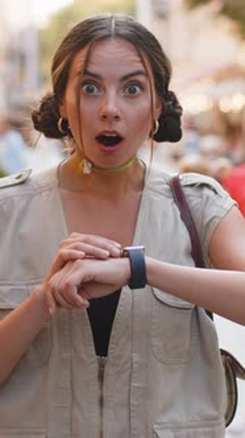 Excited Young Woman Checks Smartwatch on City Street