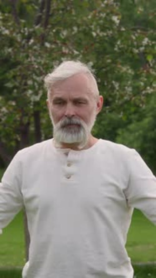 Senior Caucasian Man Participating in Group Workout in Park