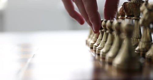 Schach spielen. Mann macht den ersten Zug mit dem Bauern, Nahaufnahme