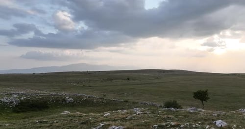 Luftaufnahme von Wiesen, die an einem bewölkten Tag auf dem Land mit weichem Nebel bedeckt sind