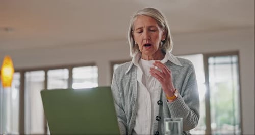Senior Woman Consults Doctor Online with Laptop