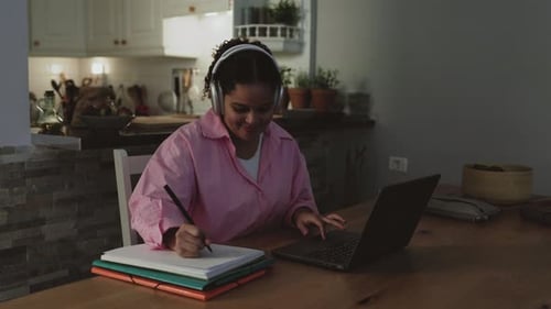 Young Adult Studying With Laptop and Notebook