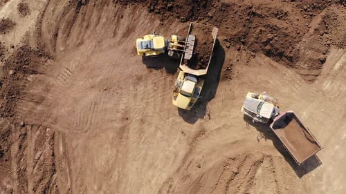 Excavator loading soil onto an Articulated hauler Truck