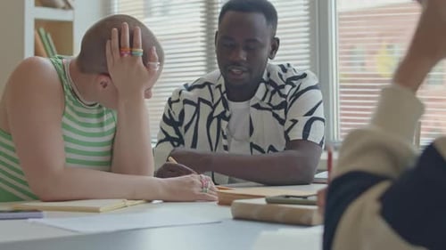 Black Student Helping Female Groupmate during College Class