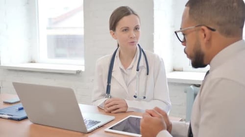 Female Doctor Talking with Patient in Clinic