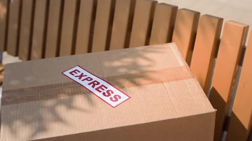 Express-Paketbox links auf einer Holzbank im Freien