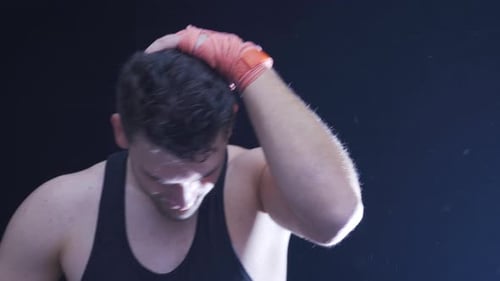 Man Training, Punching Heavy Bag in Dramatic Lighting