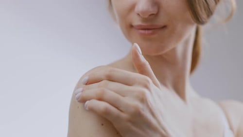 Woman Applying Cream to Her Shoulder