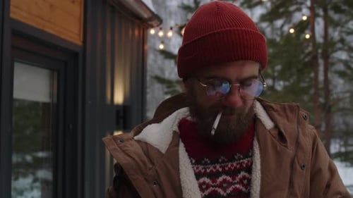 Pensive Bearded Man Smoking Cigarette Outdoors in Winter