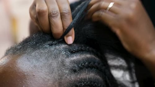 Peluquería haciendo trenzas de ganchillo para un cliente en una peluquería