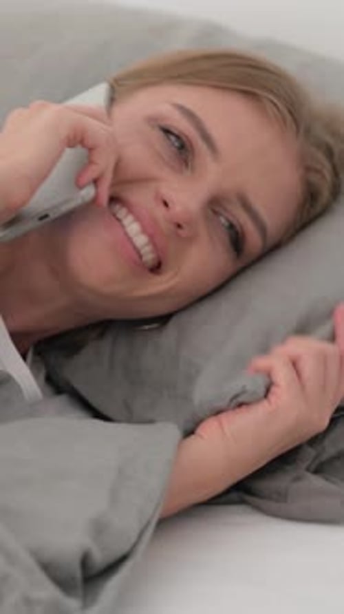 Woman Talking on the Phone Lying in Bed