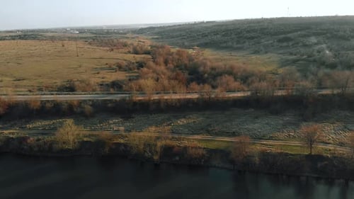 Luftbild auf zwei Straßen auf einem Hügel in der Nähe von Teich und trockenen Bäumen