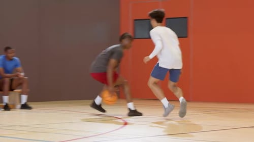 Dribbelball auf wichtige, vielfältige männliche Athleten in Sportkleidung nutzen Crossover, um die Verteidigung auf dem Platz zu besiegen