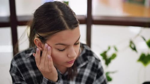 Teen Woman Touches Her Face Indoors in Daytime
