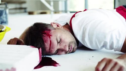 Injured Construction Worker Lying on Floor with Head Wound