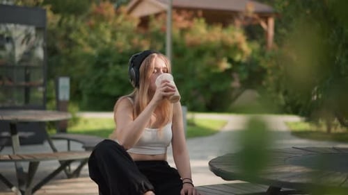 Female Individual Relaxing with Cold Coffee at Park Outdoors Young Woman Leisurely Enjoying Chilled