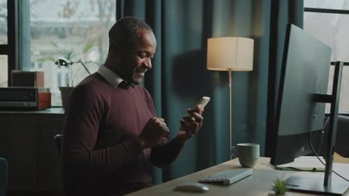 Man Using Smartphone At Desk In Home Office