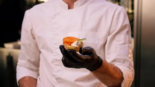 Chef Holds Prepared Salmon Appetizer in Restaurant