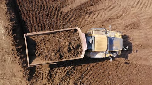 Excavator Loads Soil into Dump Truck, Aerial View