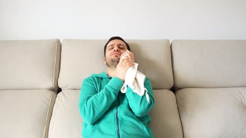 Adulte assis appliquant de la glace sur le visage pour réduire l'inflammation buccale, 4K