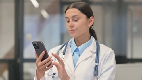 Female Doctor Using Mobile Phone in Hospital