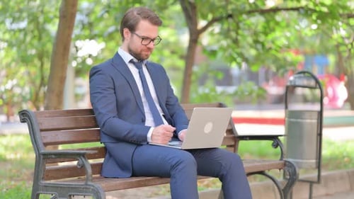 Businessman Working on Laptop in a Park