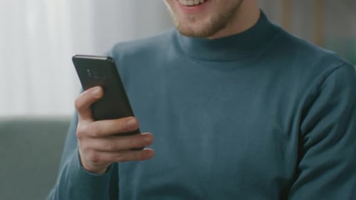 Smiling Man Using Mobile Phone Indoors