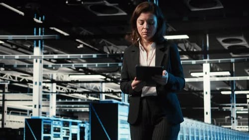 Automation Tablet and Engineer Walking in Data Center