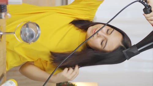 Woman Hair Styling with Hair Dryer Indoors