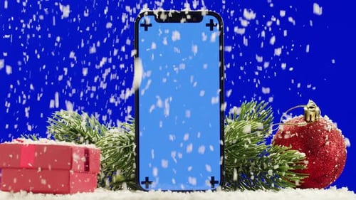Phone with Green Screen Chroma Key Near Christmas New Year Decorations on Blue Background Closeup