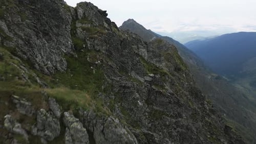 drone flies over a mountain ridge and reveals a big mountain and beautiful landscape in the backgrou