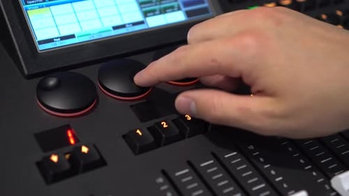 Hands of Man Turning Shuttles on Lighting Mixer Close Up
