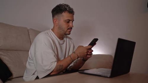 Young Adult Using Phone on Couch Indoors