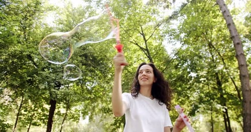 Woman Blowing Bubbles on a Sunny Summer Day