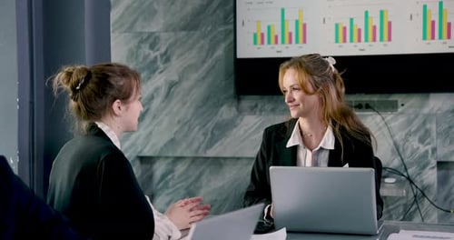 Multiracial female business team reviewing report together during professional meeting at office