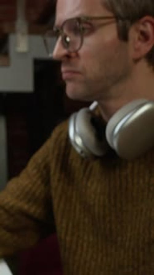 Vertical of Male Programmer Starting His Workday in Modern Office