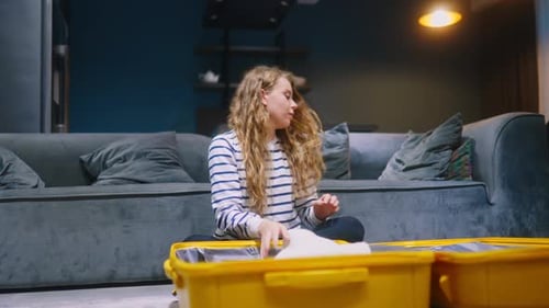 Woman Packs Suitcase for Vacation in Home